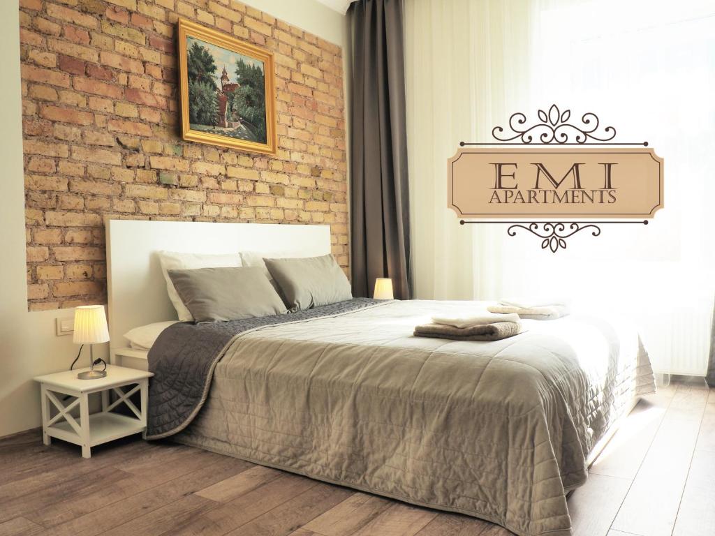 ヴィリニュスにあるEmi apartmentのベッドとレンガの壁がある寝室