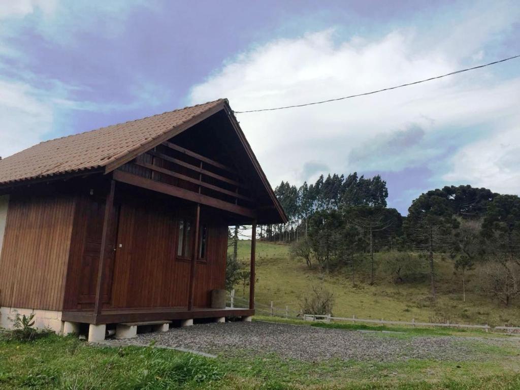 een klein gebouw met een dak op een veld bij Cantinho do Sossego in Urubici