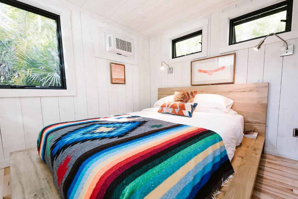 a bedroom with a bed with a colorful blanket at Caravan Outpost in Ojai