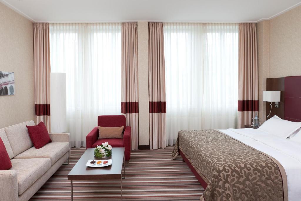 ein Hotelzimmer mit einem Bett und einer Couch in der Unterkunft Steigenberger Graf Zeppelin in Stuttgart