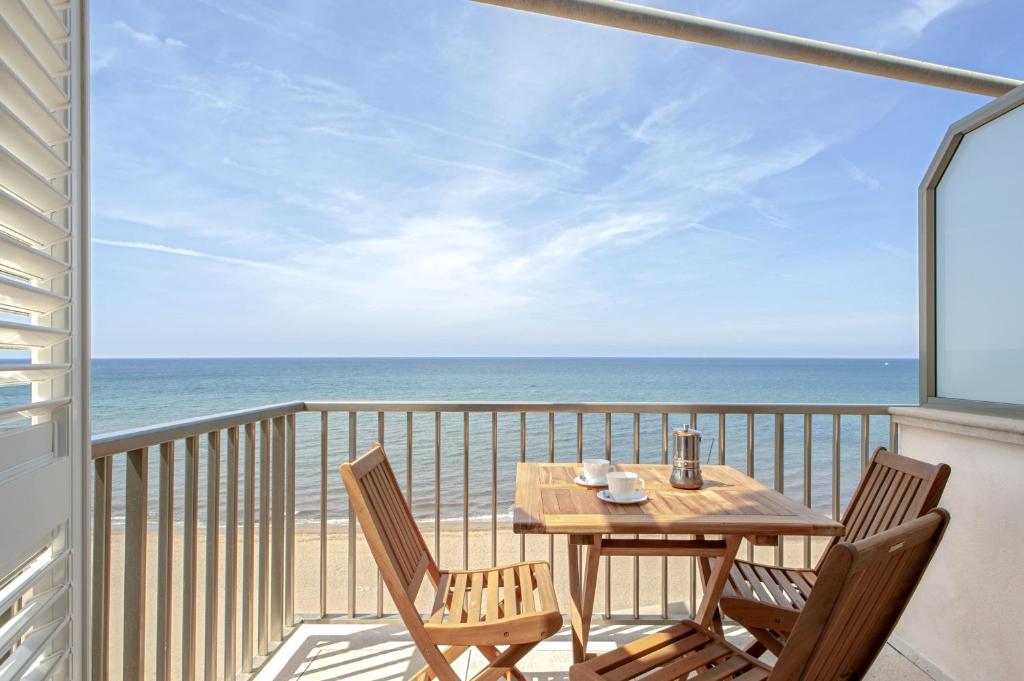 un tavolo e sedie su un balcone con vista sull'oceano di Residence Villa Lo Scoglietto a San Vincenzo