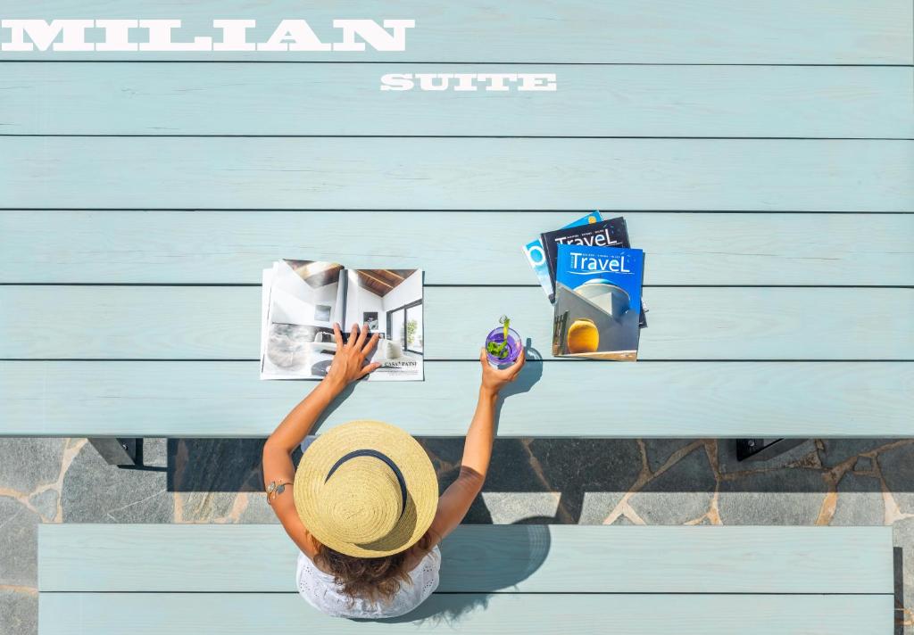 a woman in a straw hat sitting at a blue desk at Milian Suite in Adamas