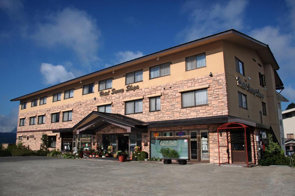 a large brown brick building with a lot of windows at Hotel Sunny Shiga in Yamanouchi