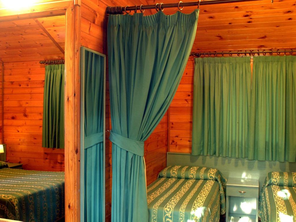 a bedroom with two beds and green curtains at Residence Villaggio Verde in Sorrento