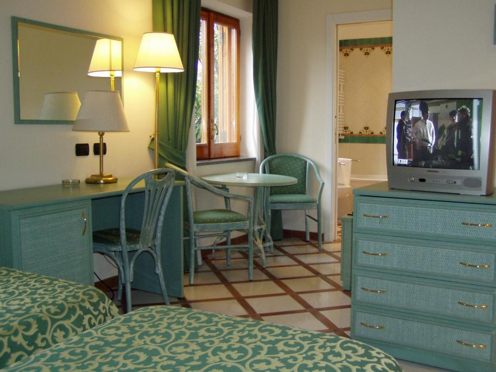 a hotel room with a television and a bedroom at Residence Villaggio Verde in Sorrento