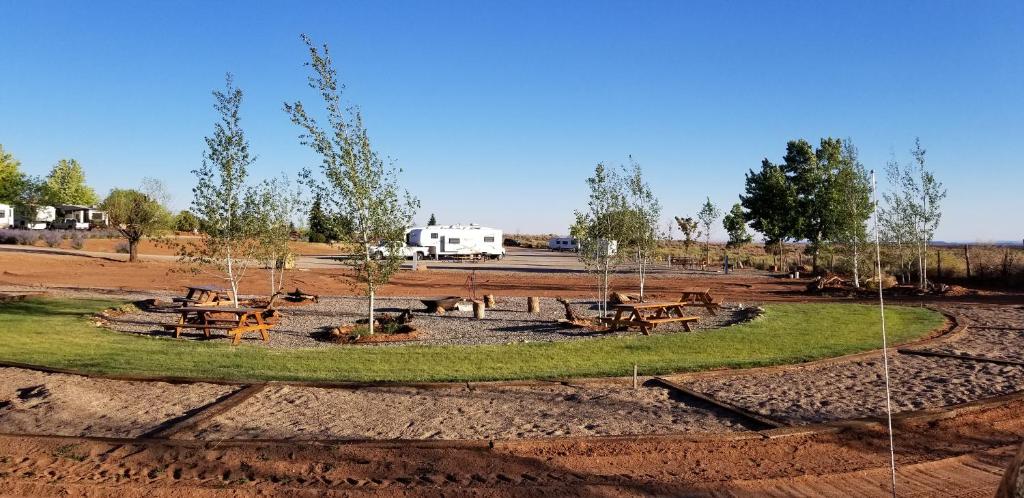 une aire de pique-nique avec des tables de pique-nique au milieu d'un champ dans l'établissement Blue Mountain RV Park, à Blanding