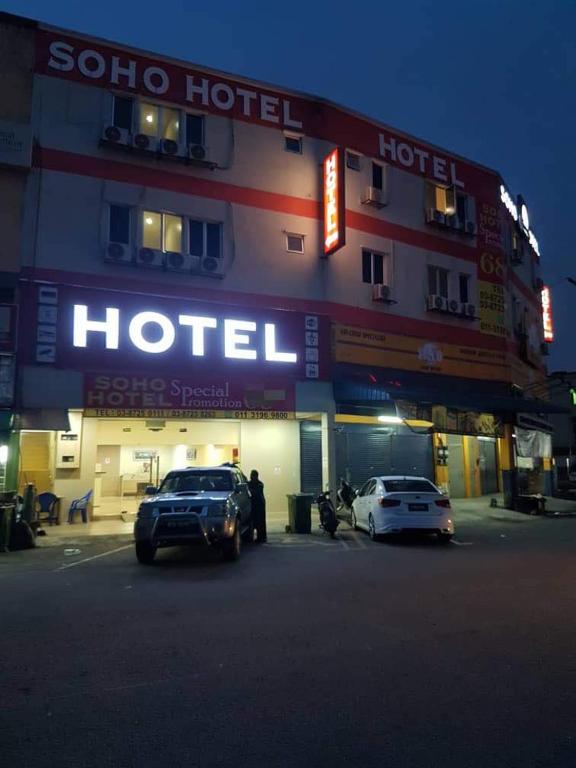a hotel with two cars parked in front of it at Soho Hotel Semenyih in Semenyih