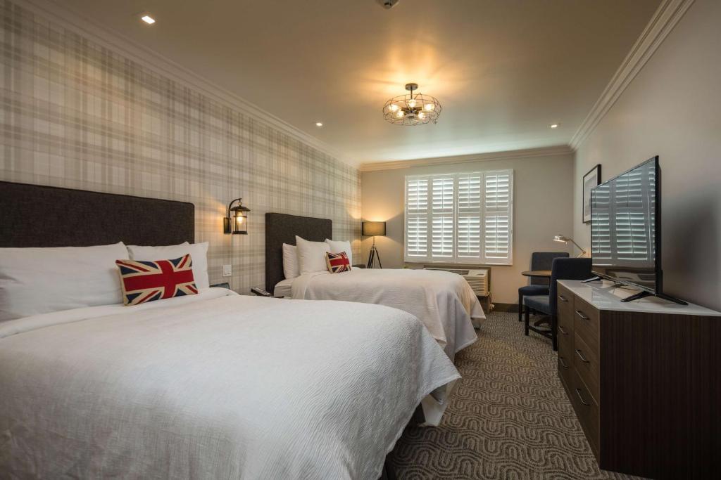 a hotel room with two beds and a television at Aristocrat Hotel, BW Signature Collection in Half Moon Bay