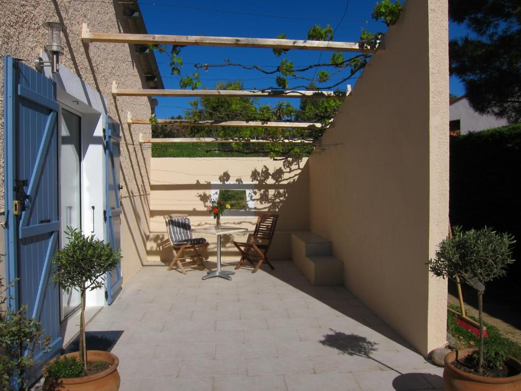 eine Terrasse mit einem Tisch und Stühlen darauf in der Unterkunft Le Quatorze in Laroque-des-Albères