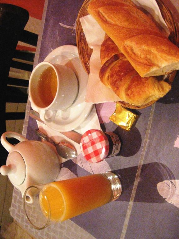 einen Tisch mit einer Tasse Kaffee und einem Korb Brot in der Unterkunft Hôtel du Pont Neuf in Paris