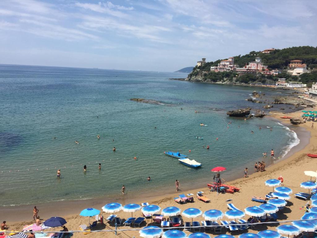 una spiaggia con ombrelloni e persone in acqua di Nonno Alberice a Rosignano Marittimo