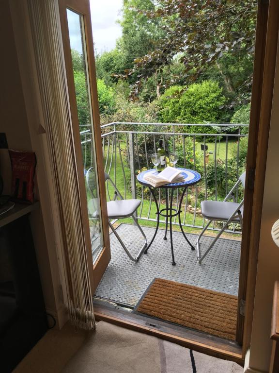 a door open to a balcony with a table and chairs at The Lavender Room in Saundersfoot