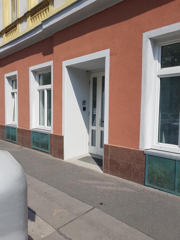 a orange and white building with a white door at Pension am Wienfluss in Vienna