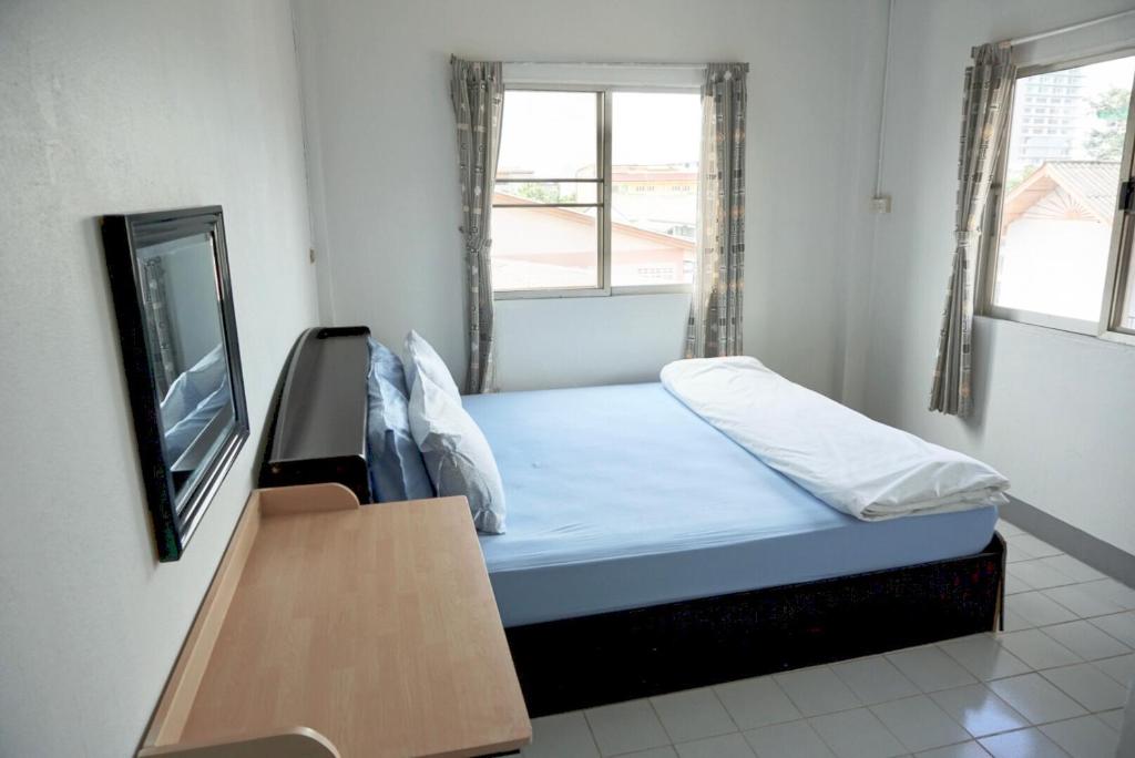 niewielka sypialnia z łóżkiem i telewizorem w obiekcie Tourist Inn w mieście Chiang Rai