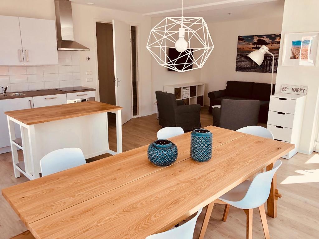 eine Küche und ein Wohnzimmer mit einem Holztisch und Stühlen in der Unterkunft ApartHotel Zoutelande in Zoutelande