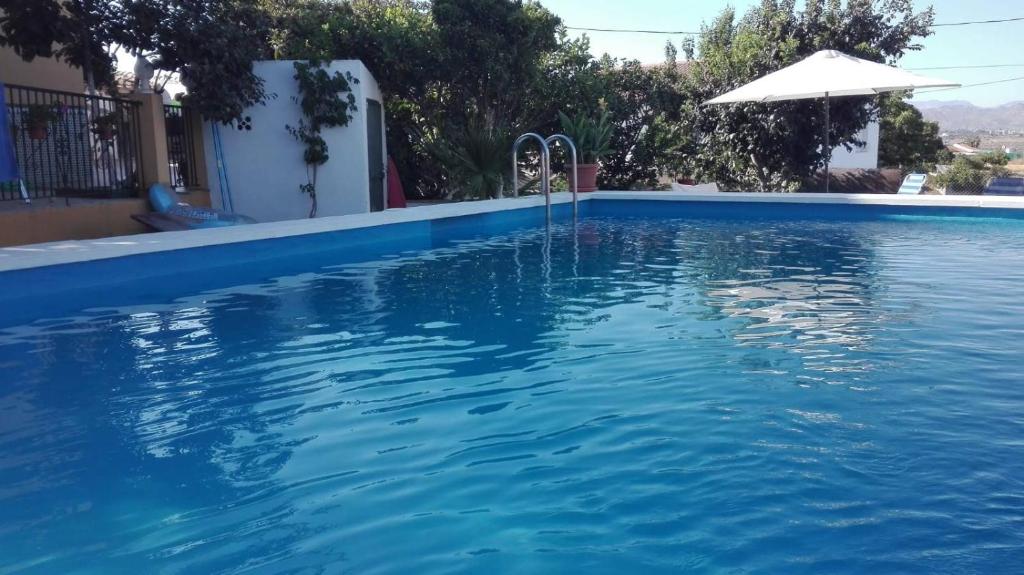 ein Pool in einem Haus mit Sonnenschirm in der Unterkunft La Casita de Silvia in Alhaurín de la Torre