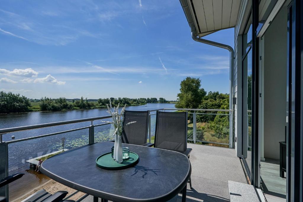 einen Tisch auf einem Balkon mit Flussblick in der Unterkunft Eiderstrand in Tielen