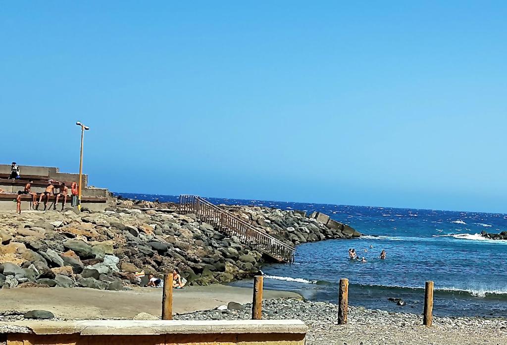 einen Strand mit Menschen, die im Wasser schwimmen in der Unterkunft Apartamento muelle in Pozo Izquierdo