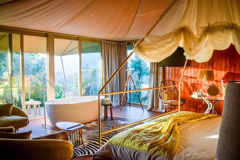 a bedroom with a bed and a bath tub in it at Carmo's Boutique Hotel - Small Luxury Hotels of the World in Ponte de Lima