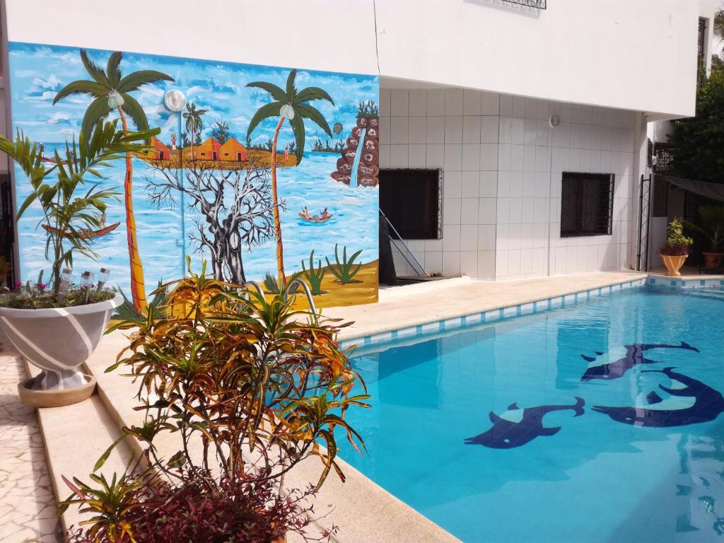 ein großer Pool mit einem Wandbild von Delfinen in der Unterkunft Villa Massilia in Saly Portudal