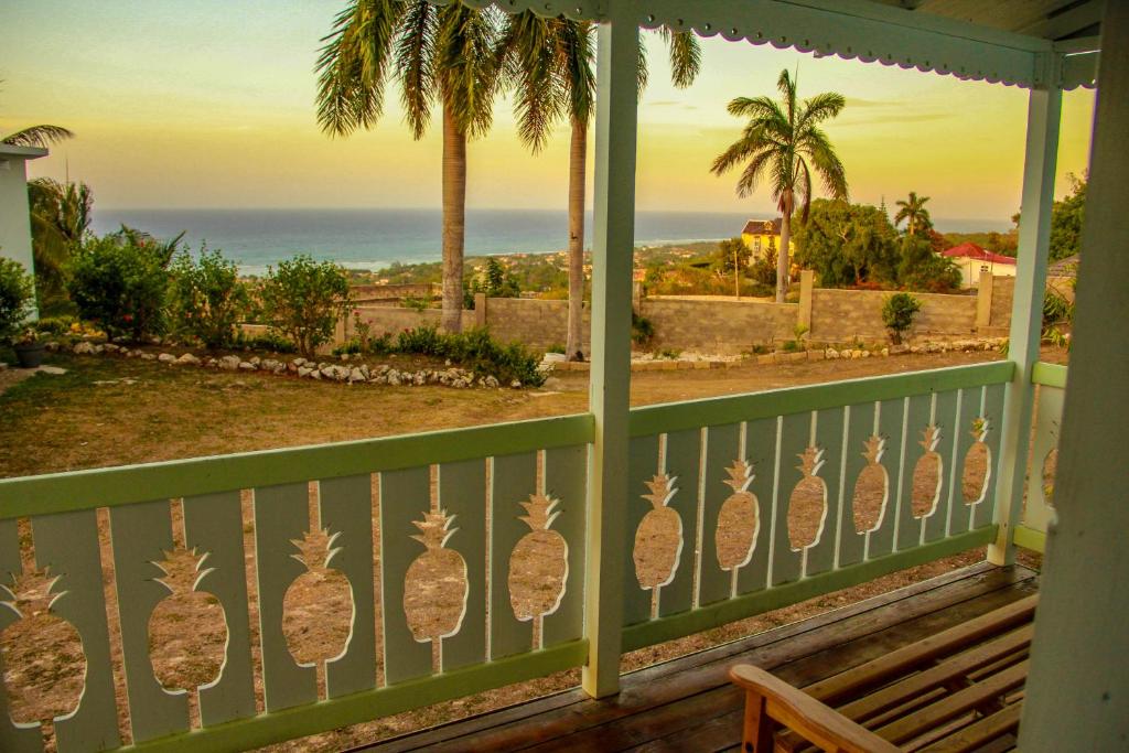 a porch with a fence with pineapple decals on it at Sunshine Lodge: Your home away from home in Montego Bay