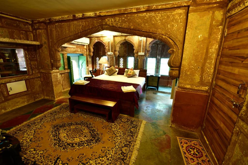 a bedroom with a bed and a table in a room at The Arch Boutique Home stay in Jodhpur