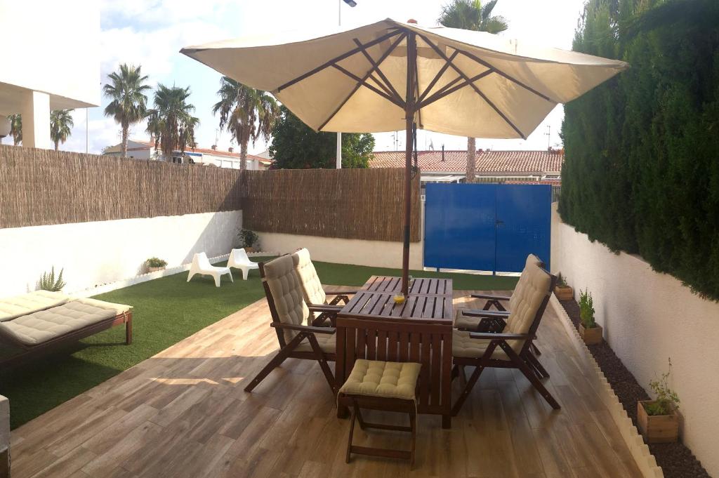 einen Tisch und Stühle mit Sonnenschirm auf einer Terrasse in der Unterkunft Apartamento Santa Pola in Santa Pola