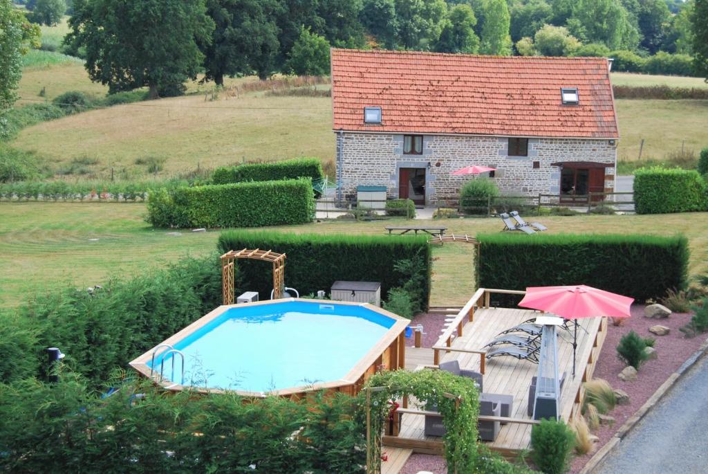 une maison avec une piscine en face d'une maison dans l'établissement Rustic and spacious converted Barn, à Isigny-le-Buat