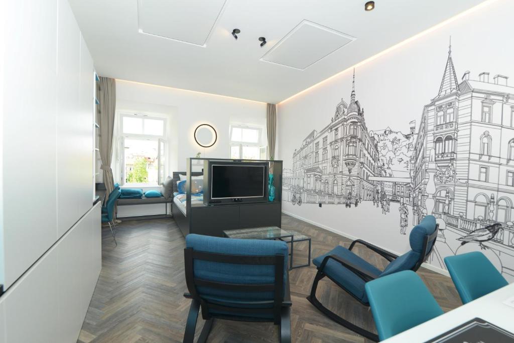 a living room with a tv and blue chairs at RIVER SIDE CENTRAL MARKET - Eclipse superior apartment in Ljubljana