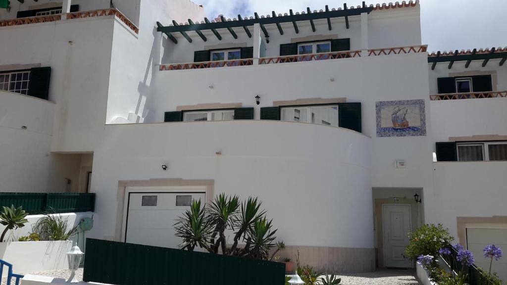 a white building with some plants in front of it at Casa Manuela in Ericeira