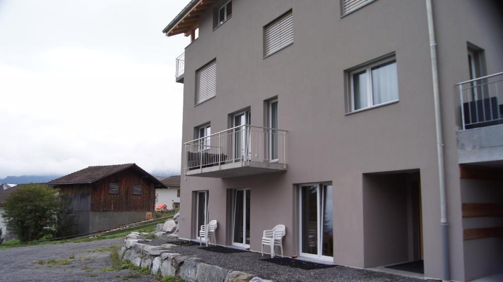 a white building with two white chairs next to it at Haus Baracca in Vella