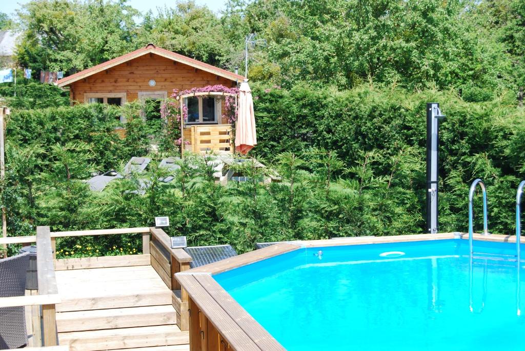 The Cabin with heated outdoor pool في Chalandrey: مسبح في حديقه خلفيه مع منزل