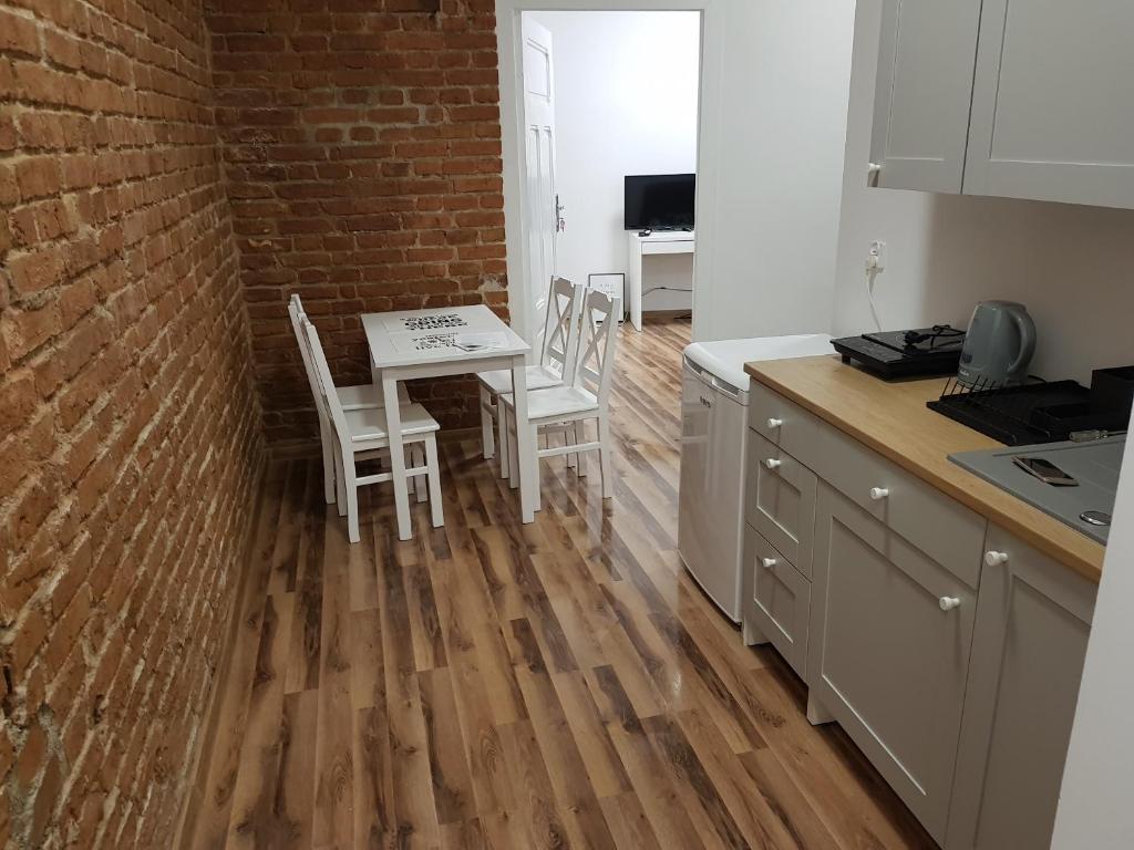 a kitchen with a table and chairs and a brick wall at Apartament nr 15 - 2 pokoje z prywatnymi łazienkami Centrum Poznań in Poznań