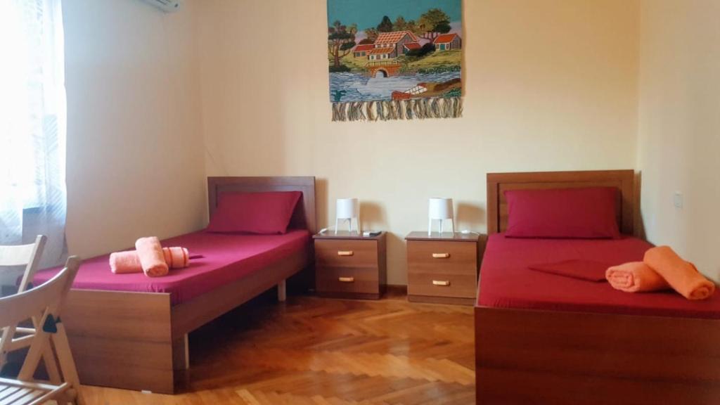 Dos camas en una habitación con sábanas rosas. en Elisabet Tirana, en Tirana