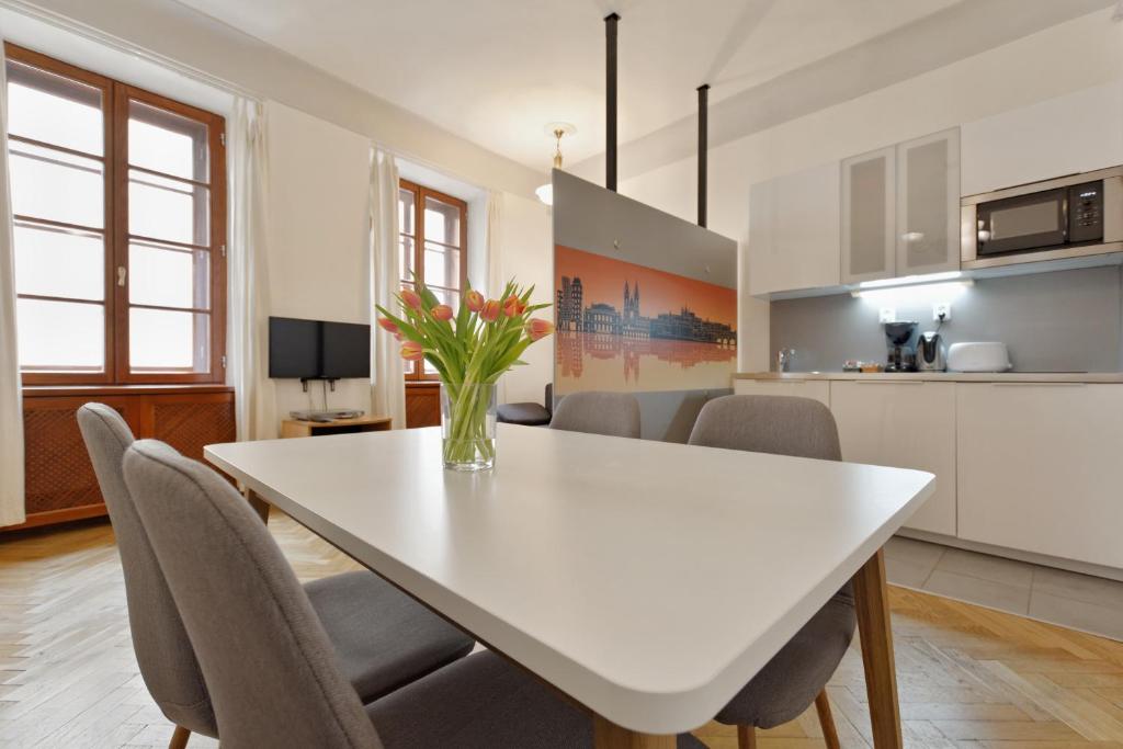 cocina y comedor con mesa blanca y sillas en Historic Centre Apartments VIII, en Praga