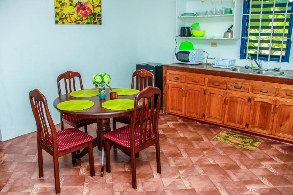 a kitchen with a table and chairs and a sink at Sunshine Lodge: Your home away from home in Montego Bay