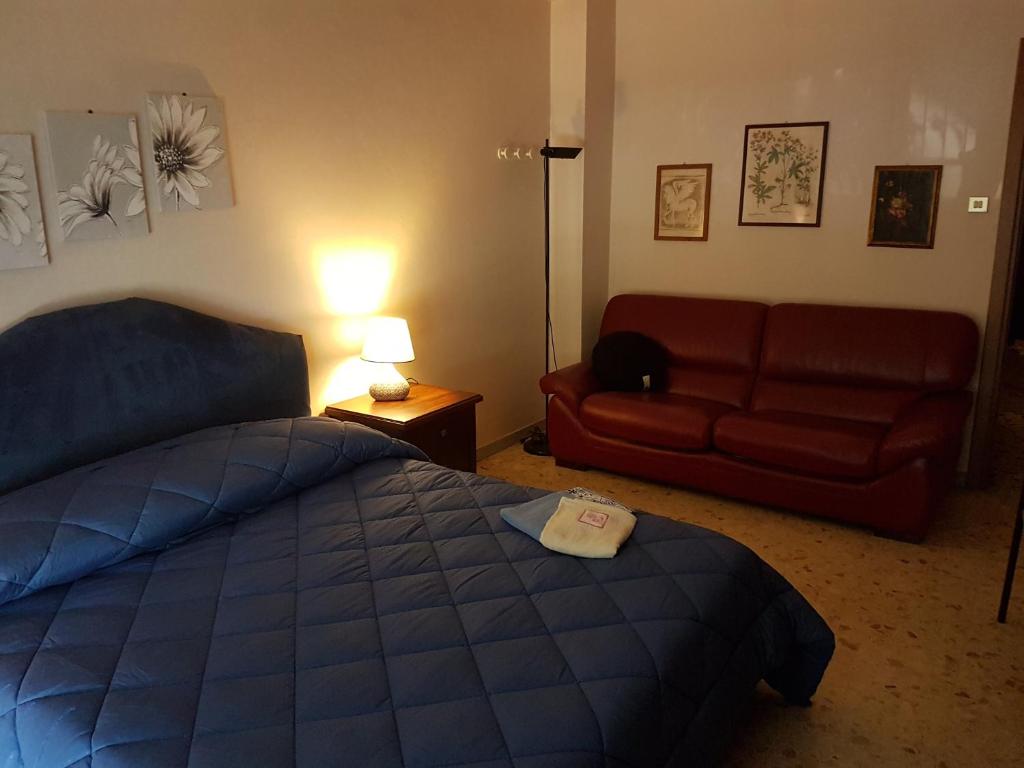 a bedroom with a bed and a red couch at Mammo's House in Rome