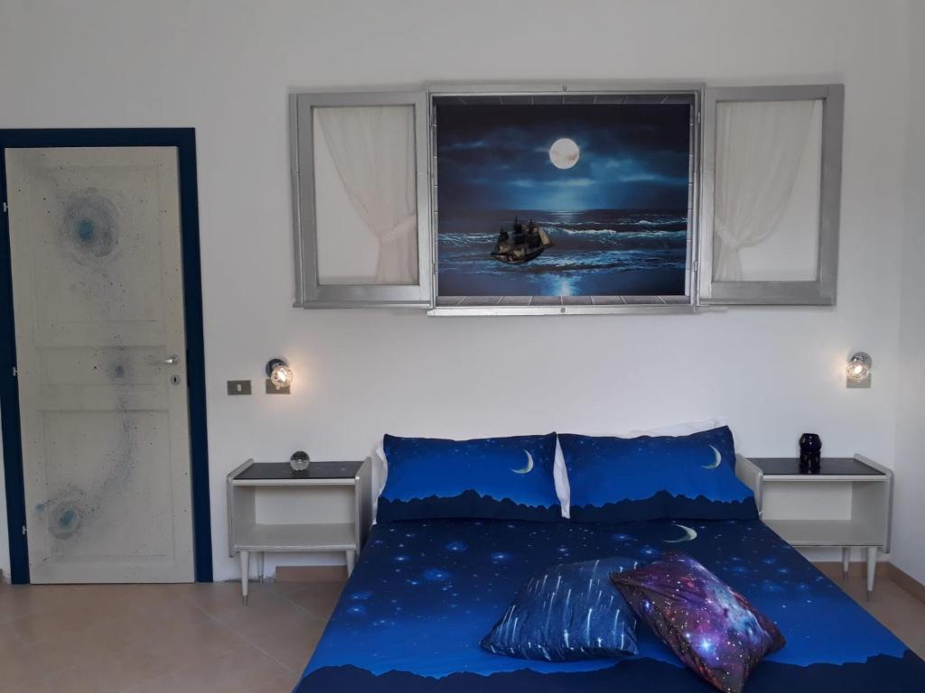 ヴィッラ・サン・ピエトロにあるAl 101...sogni...のベッドルーム1室(青いベッド1台、窓2つ付)
