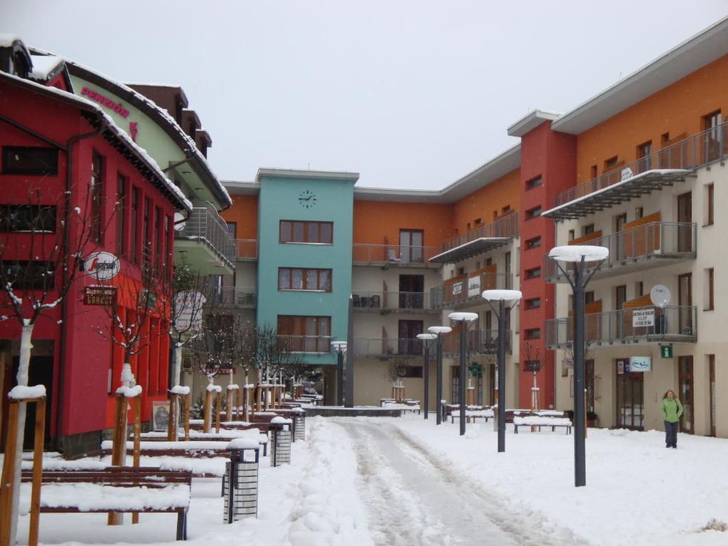a snow covered street in a city with buildings at Apartmán Karin in Oščadnica