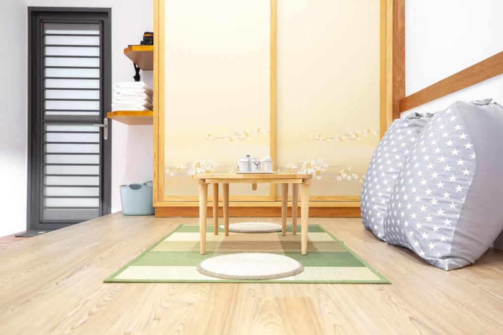 a small table on a rug next to a bed at Lost Circle Homestay in Tainan