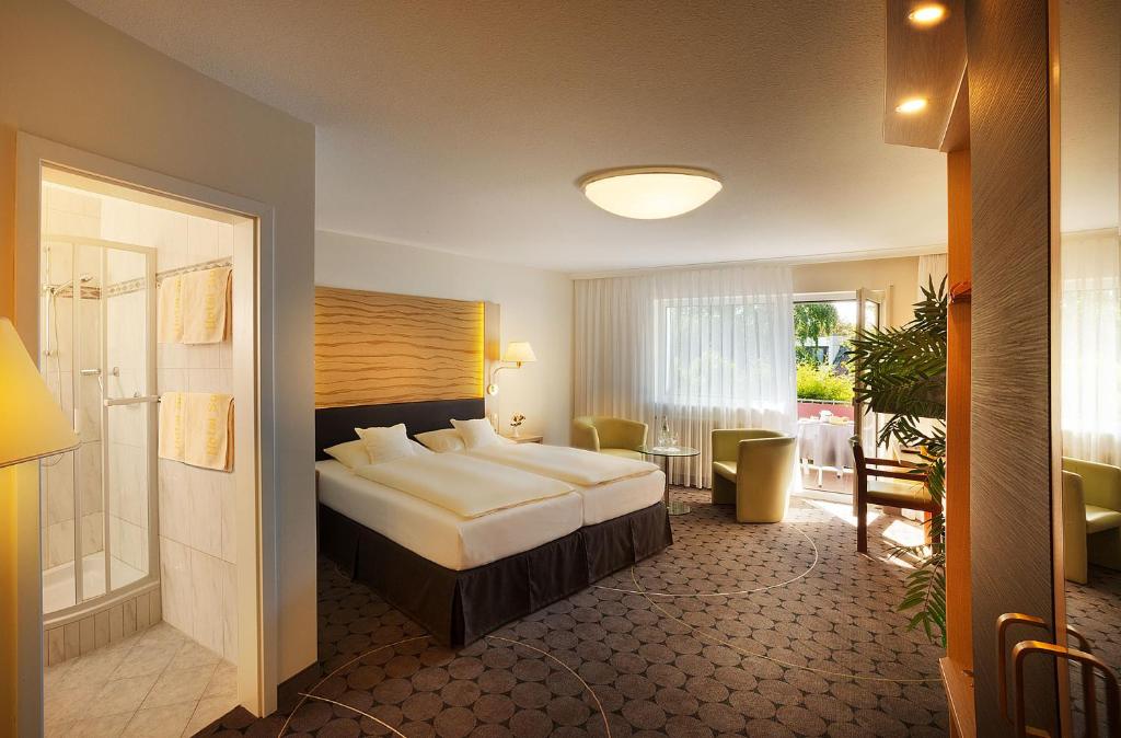 een hotelkamer met een groot bed en een tafel bij Hotel Sonneneck in Bad Kissingen