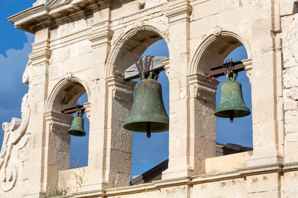 two bells on the side of a building at Maison Ortigia in Syracuse