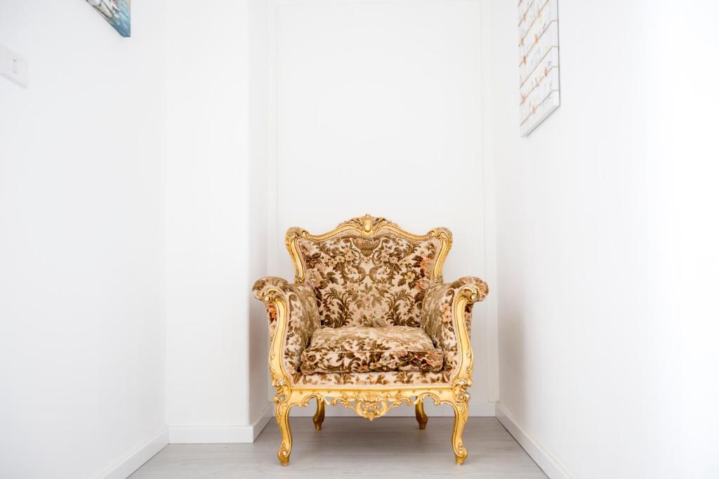 a gold chair sitting in a corner of a room at Maison Ortigia in Syracuse