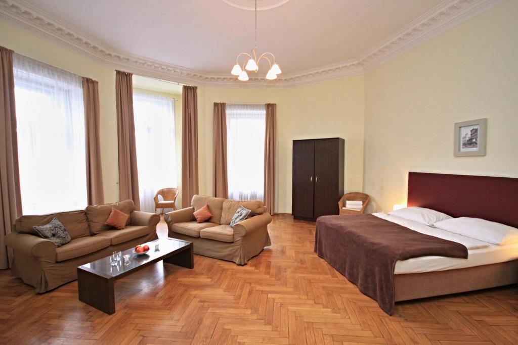 a bedroom with a bed and a couch and a table at River View Residence in Prague