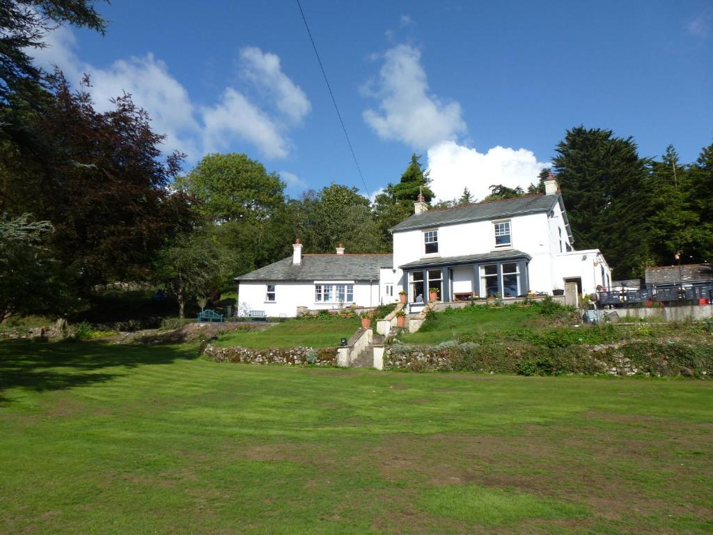 a white house sitting on top of a green field at Uplands Inn Cartmel in Cartmel