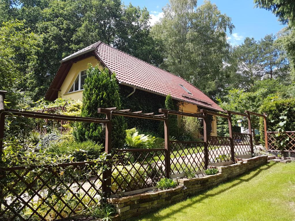 a fence in front of a house with a garden at Ferienwohnung Mittelmühle in Teupitz