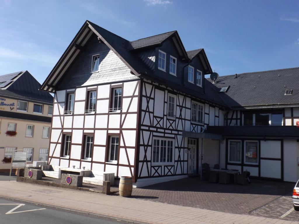 a white and black building with a black roof at Deutsches Haus in Willingen