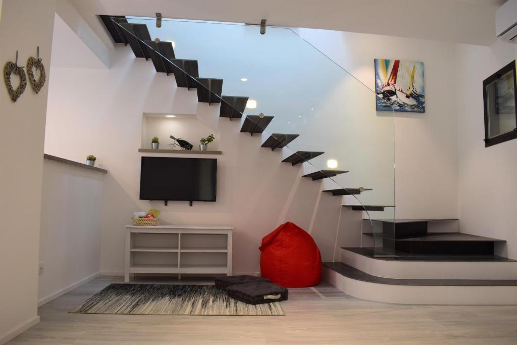 a living room with a staircase with a tv at Appartamento Oleandro in Arco