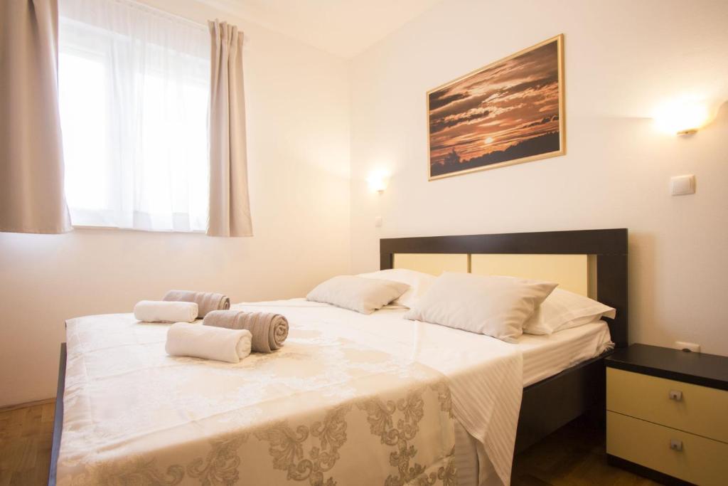 1 dormitorio con 1 cama grande y 2 toallas. en Apartments Paradise, en Trogir