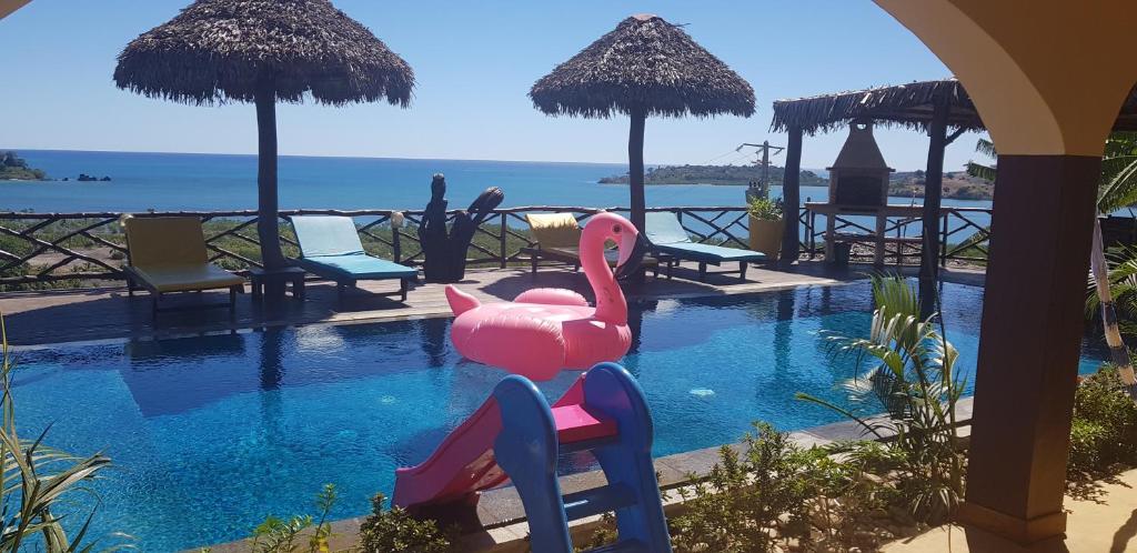 una piscina con dos flamencos rosas en el agua en villa nosy détente, en Nosy Be